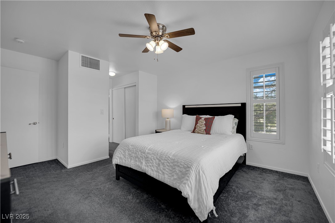 1909 Mountain Hills Court, Unit 205 Las Vegas, NV 89128 - Photo 23 of 34 Bedroom with dark colored carpet, a ceiling fan, and a closet