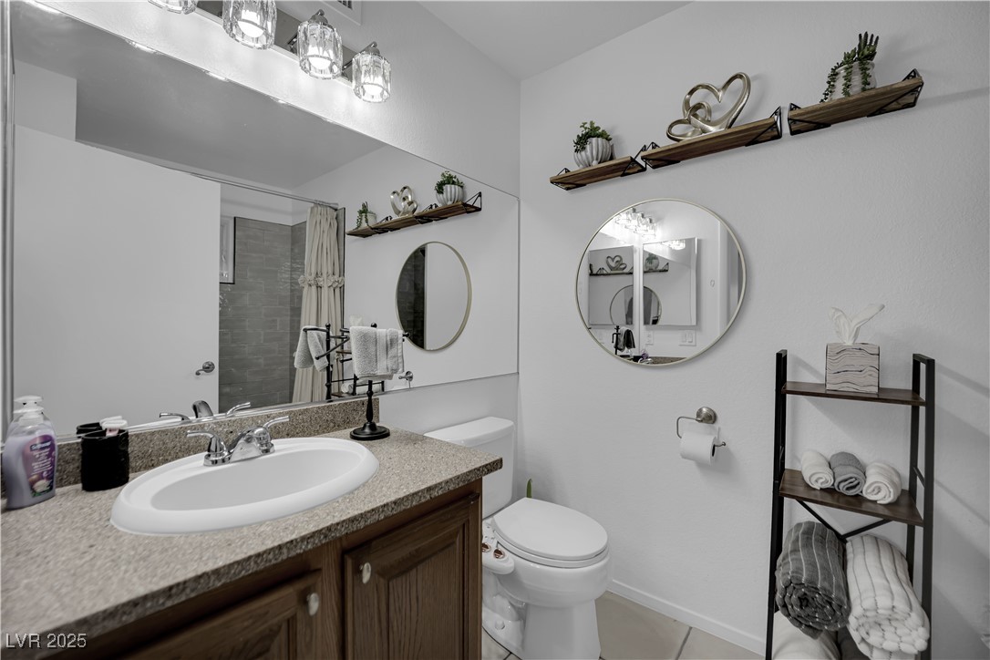 1909 Mountain Hills Court, Unit 205 Las Vegas, NV 89128 - Photo 26 of 34 Full bath with vanity, tiled shower, and light tile patterned flooring