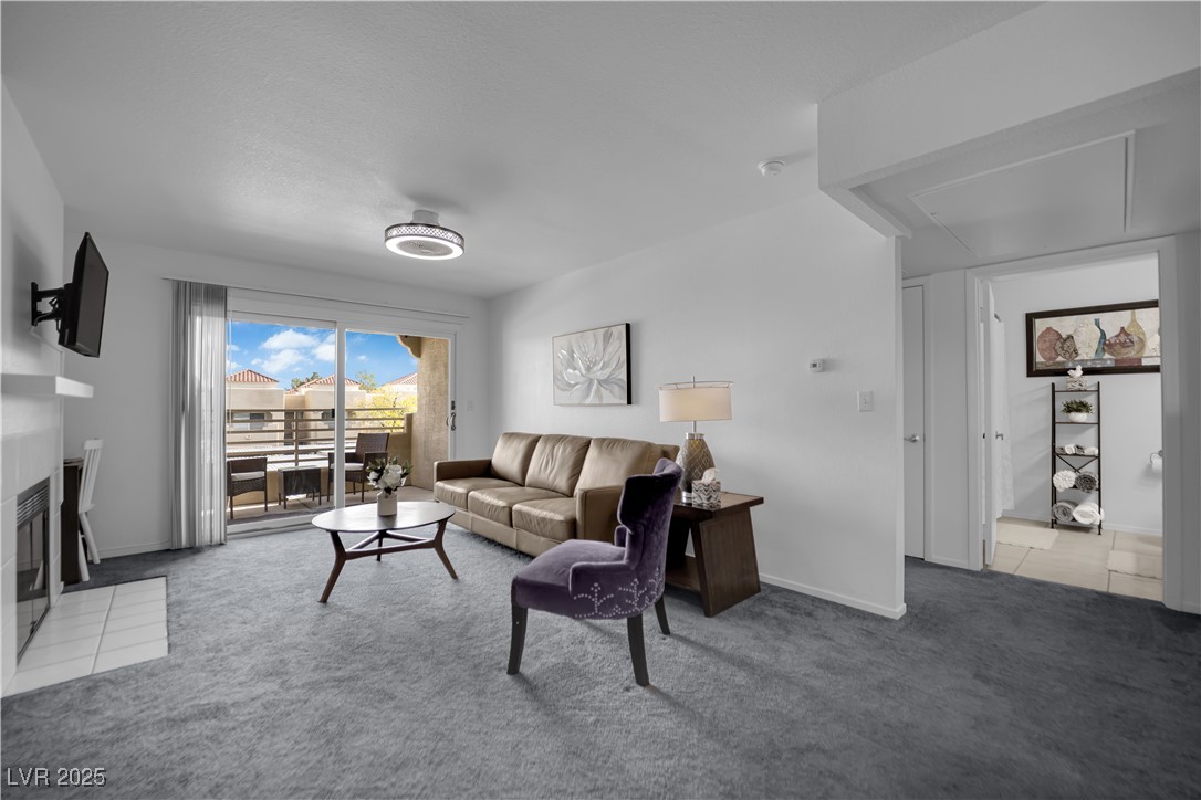 1909 Mountain Hills Court, Unit 205 Las Vegas, NV 89128 - Photo 6 of 34 Living area featuring a fireplace with flush hearth and light colored carpet