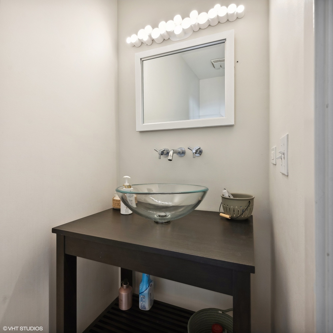 1040 West Adams Street, Unit 601 Chicago, IL 60607 - Photo 12 of 13 a bathroom with a sink a mirror and a toilet