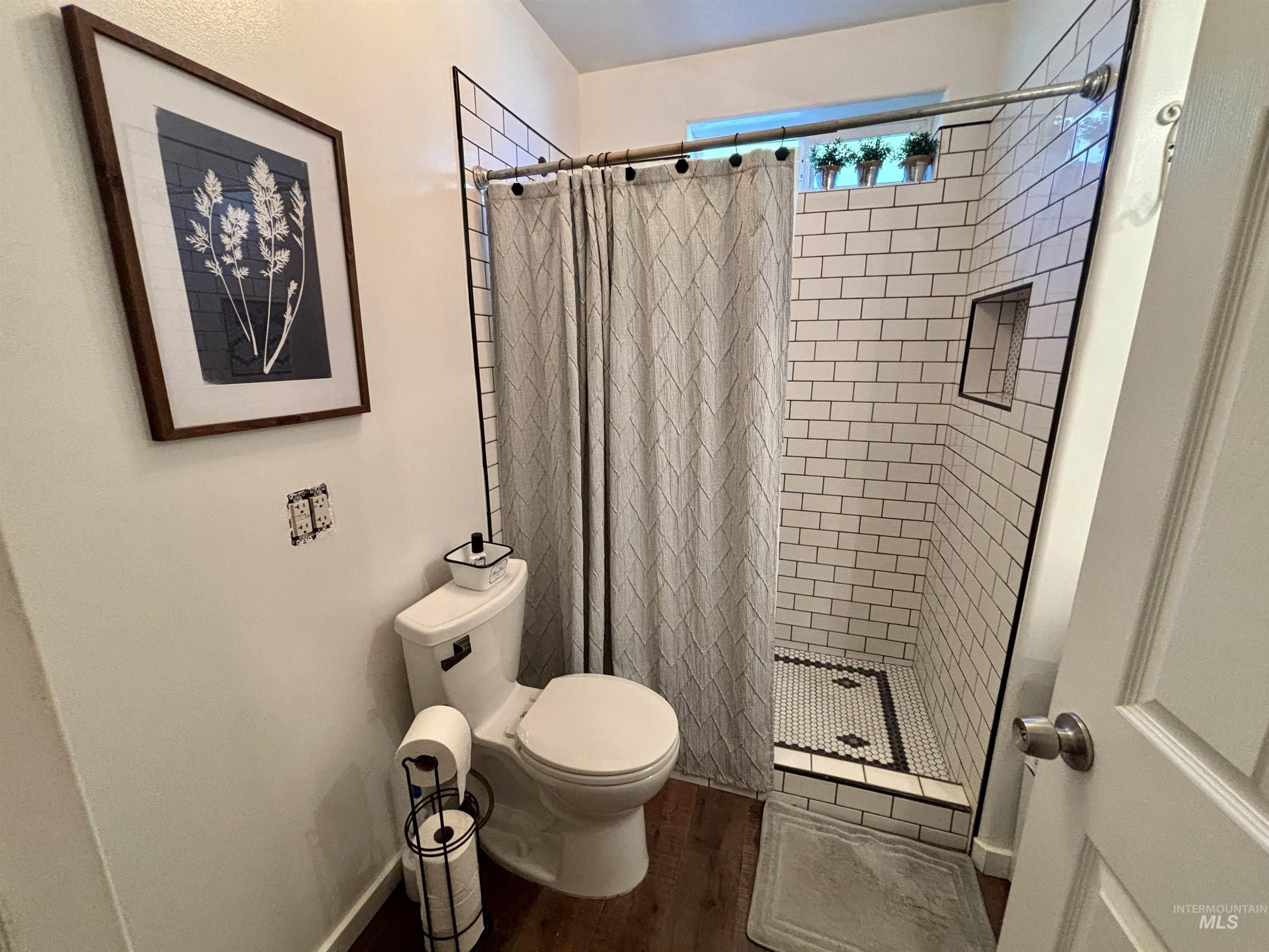 23626 Boise River Road Caldwell, ID 83607 - Photo 28 of 49 Shower featuring white subway tile surround, recessed niche, and mosaic tile flooring