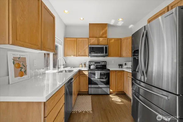 a kitchen with stainless steel appliances a refrigerator sink and stove
