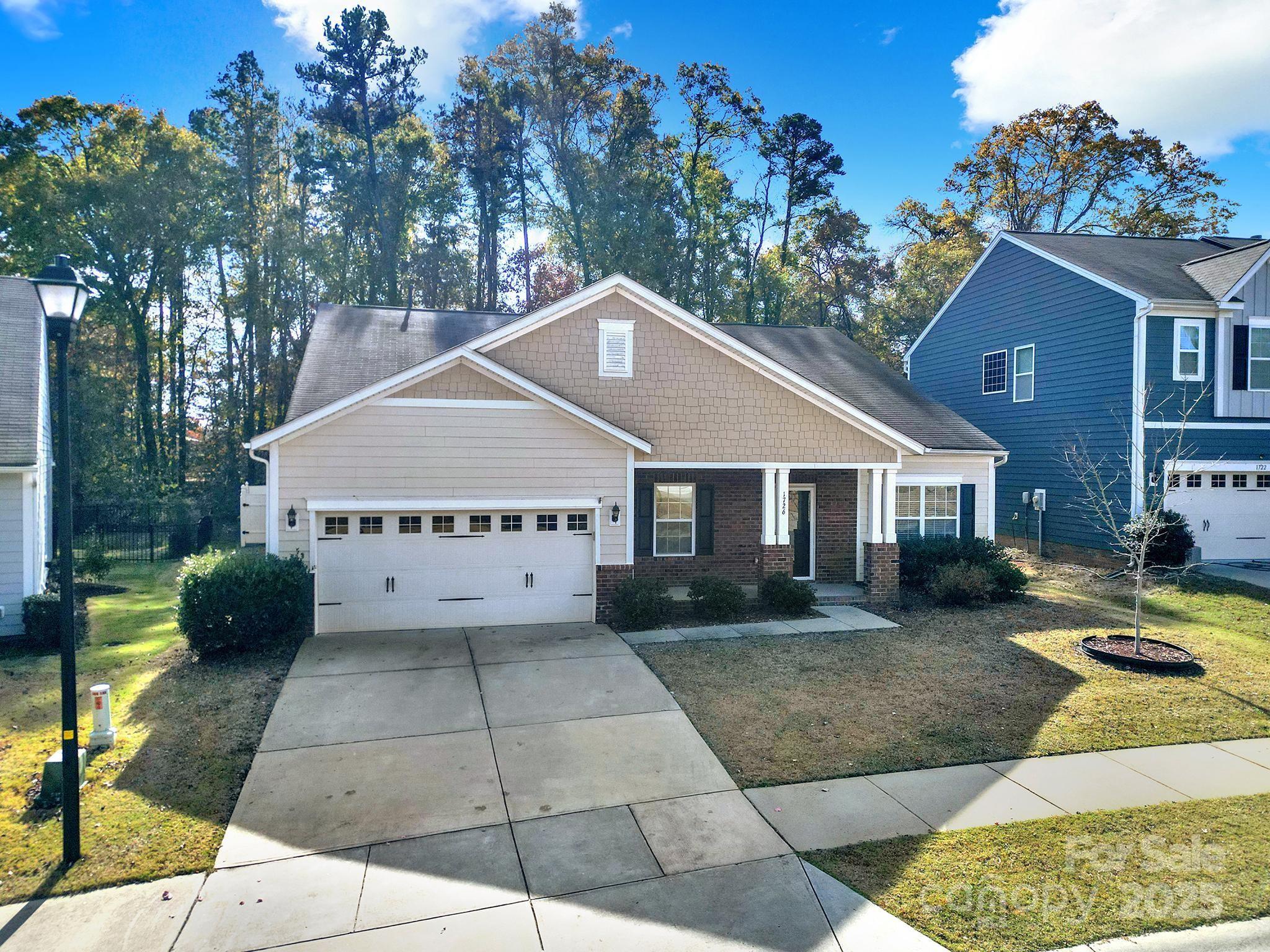 1726 Still River Way Fort Mill, SC 29708 - Photo 2 of 45 a front view of a house with a yard garage and outdoor seating