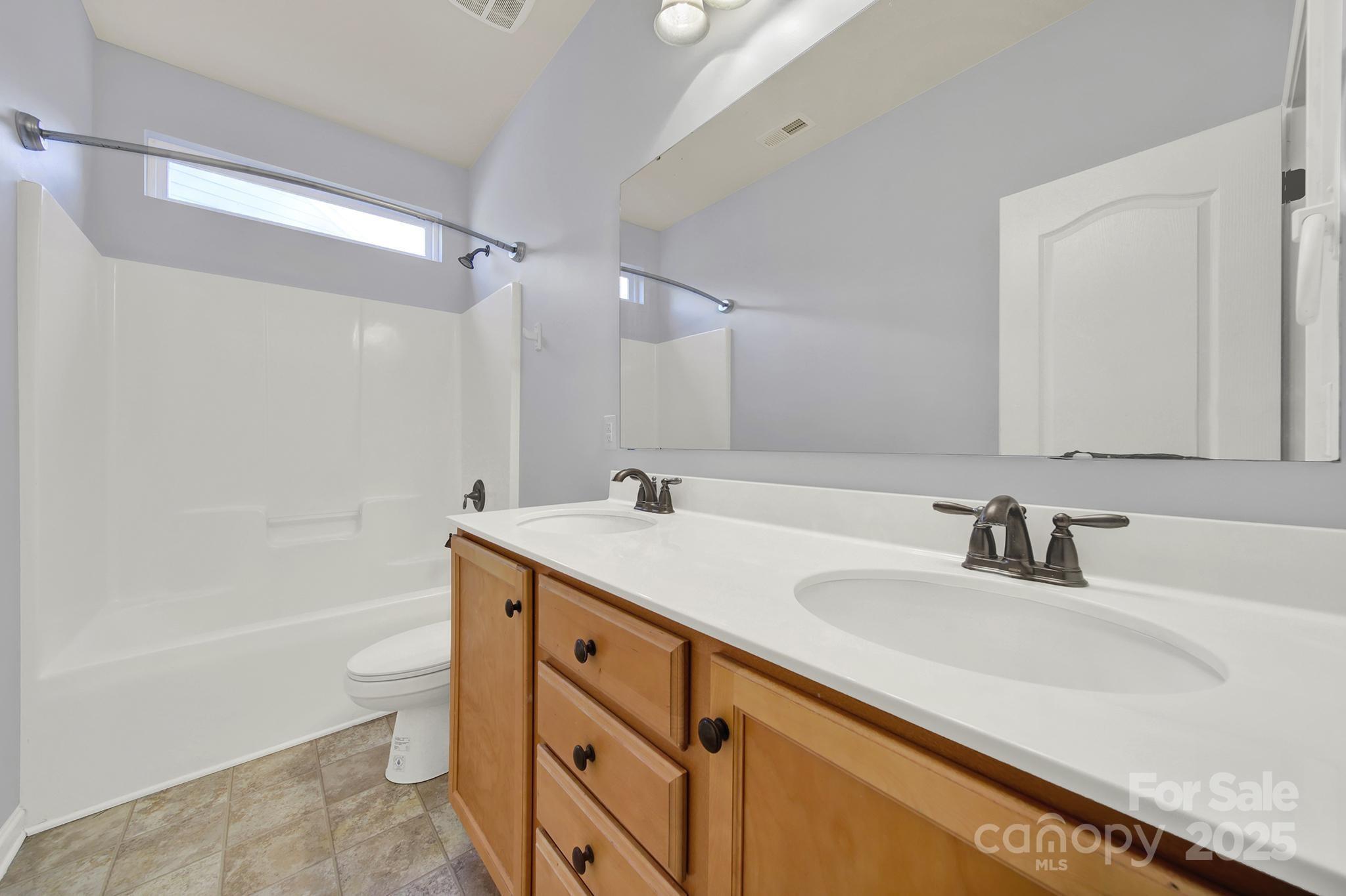 1726 Still River Way Fort Mill, SC 29708 - Photo 27 of 45 a bathroom with a sink double vanity granite toilet and a bathtub