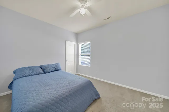 a bedroom with a bed and a chandelier fan