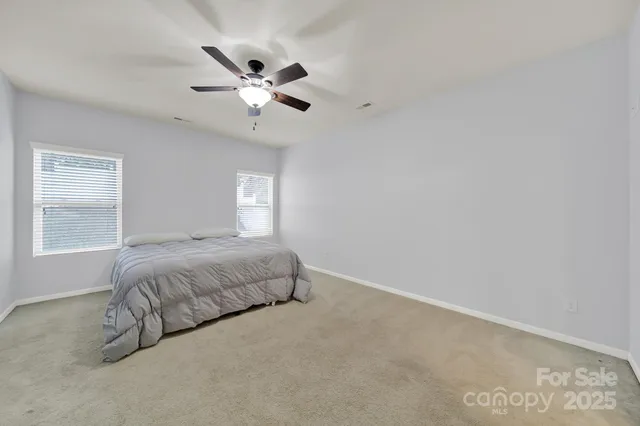 a spacious bedroom with a bed and a chandelier