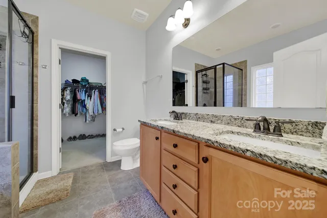 a en suite bathroom with a double vanity sink a mirror and a shower