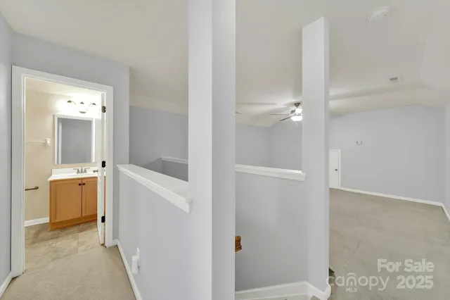 a view of bathroom with sink mirror and window