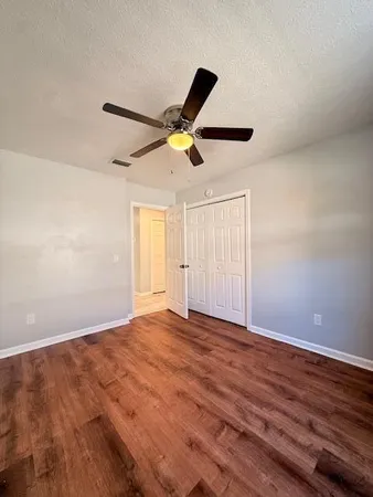 a view of an empty room with wooden floor