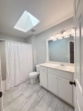 a bathroom with a double vanity sink toilet and a mirror