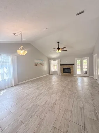 a view of empty room with fireplace and windows