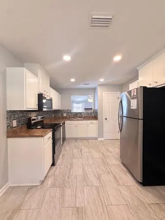 a kitchen with stainless steel appliances granite countertop a refrigerator a sink and a stove
