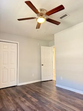 a view of an empty room with wooden floor