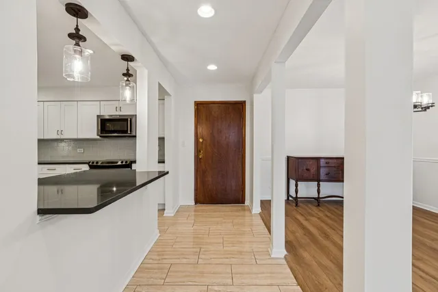 a large kitchen with stainless steel appliances granite countertop a refrigerator and a stove top oven