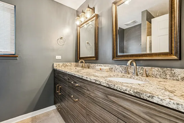 a bathroom with a granite countertop sink and a mirror
