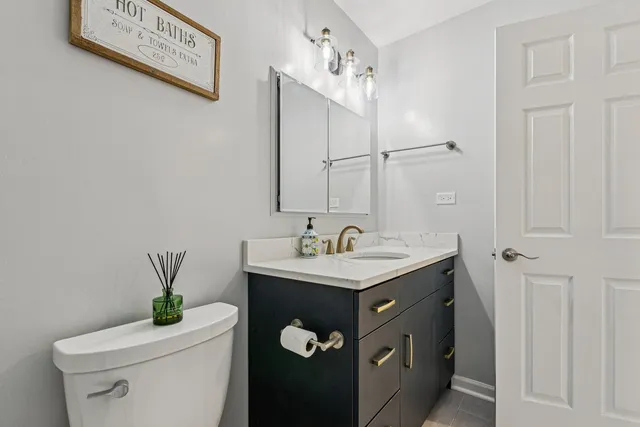 a bathroom with a toilet sink and mirror
