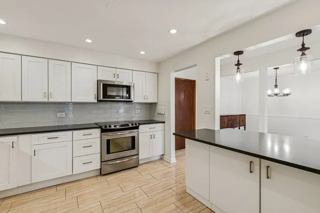 a large kitchen with cabinets stainless steel appliances and a counter space