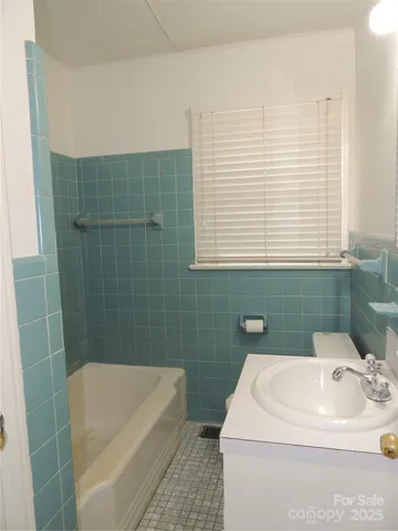 a bathroom with a sink a toilet window and shower