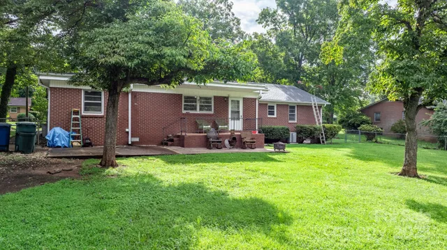 a backyard of a house with yard table and chairs