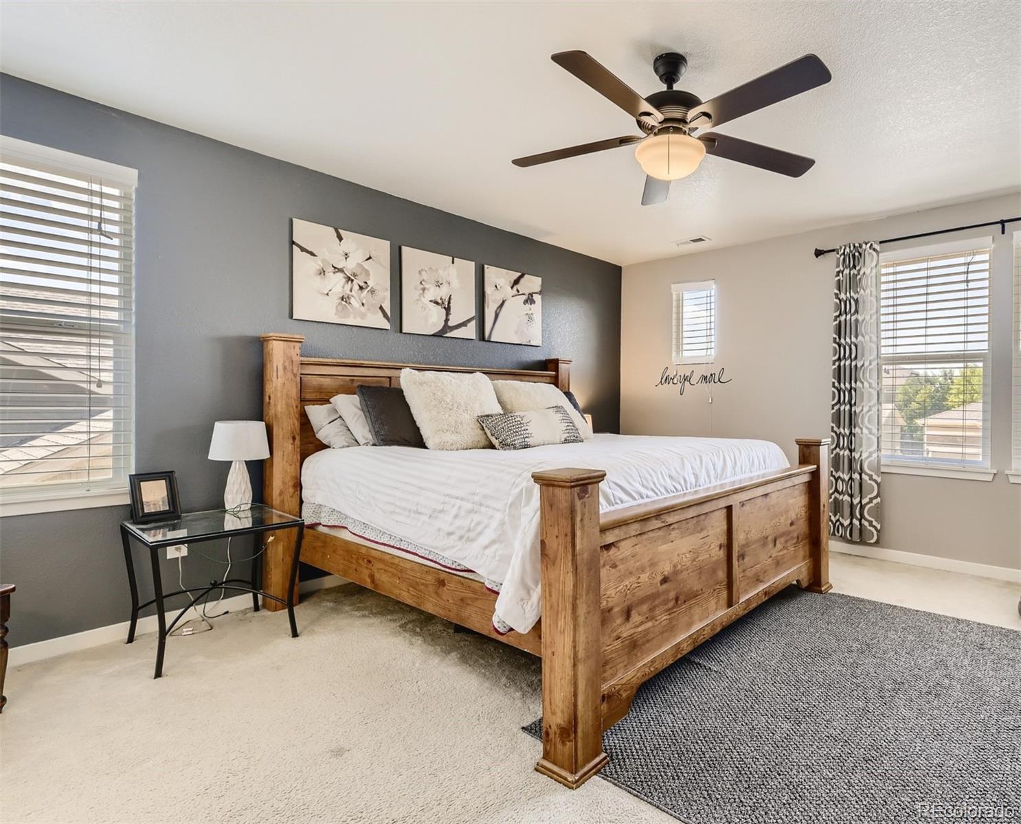 17021 White Alba Lane Parker, CO 80134 - Photo 11 of 21 a bedroom with a bed a chandelier and a large window