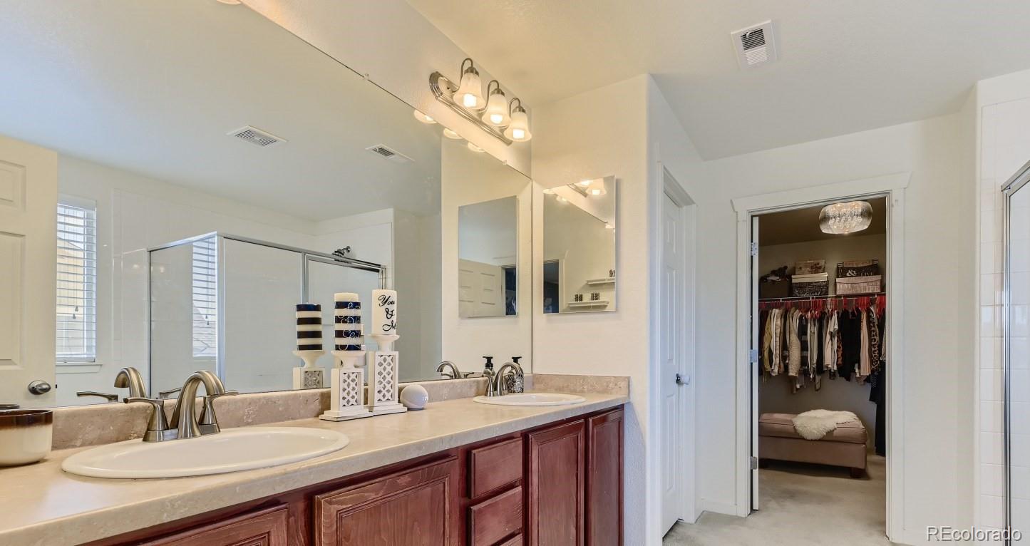 17021 White Alba Lane Parker, CO 80134 - Photo 12 of 21 a en suite bathroom with a double vanity sink and a mirror
