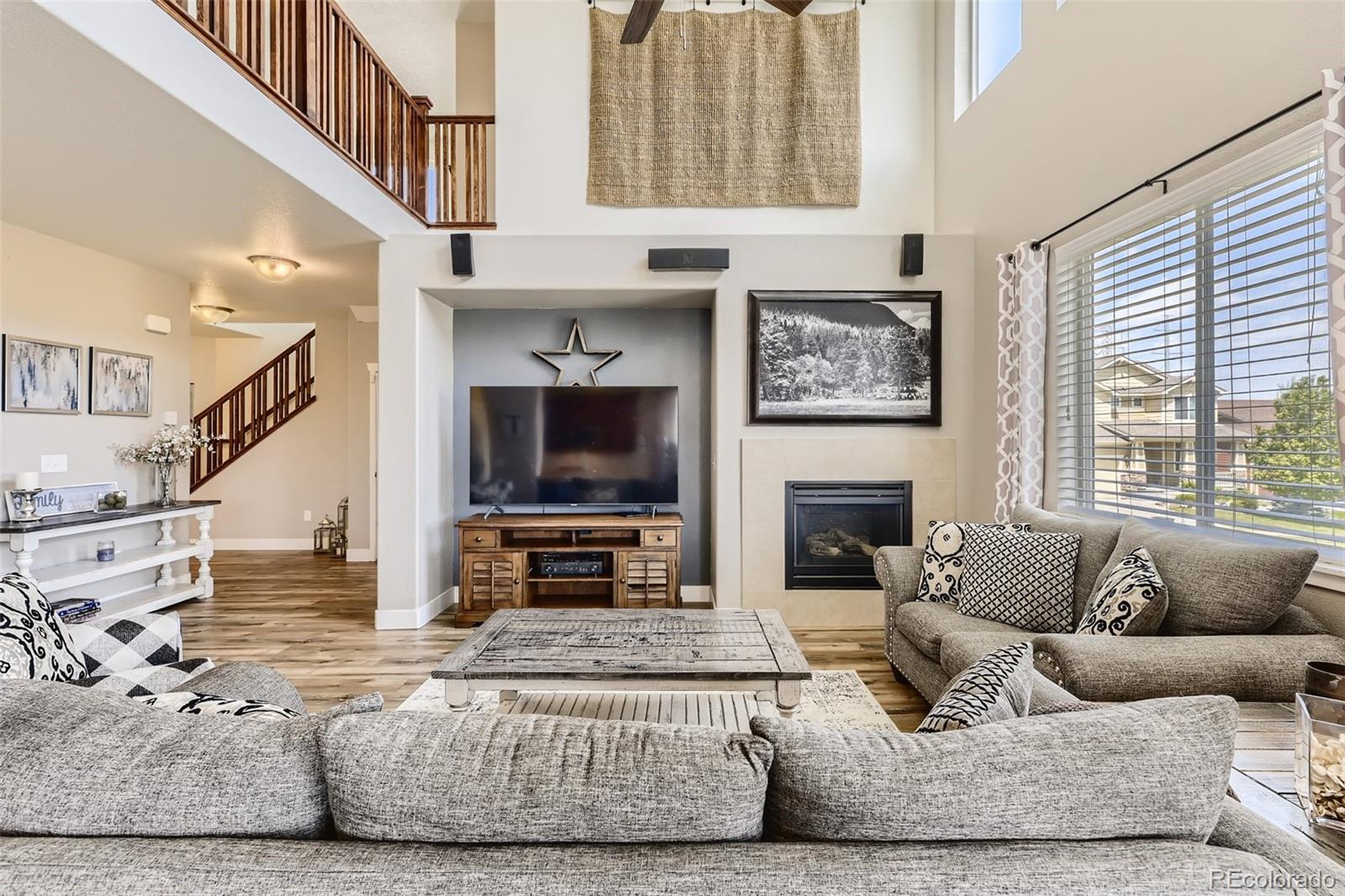 17021 White Alba Lane Parker, CO 80134 - Photo 5 of 21 a living room with furniture a fireplace and a flat screen tv