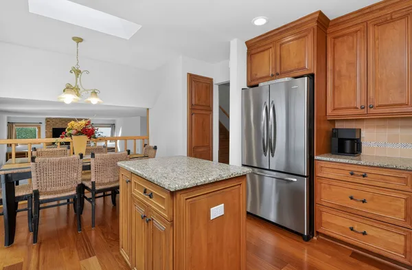 a kitchen with stainless steel appliances granite countertop wooden cabinets a refrigerator and a stove top oven