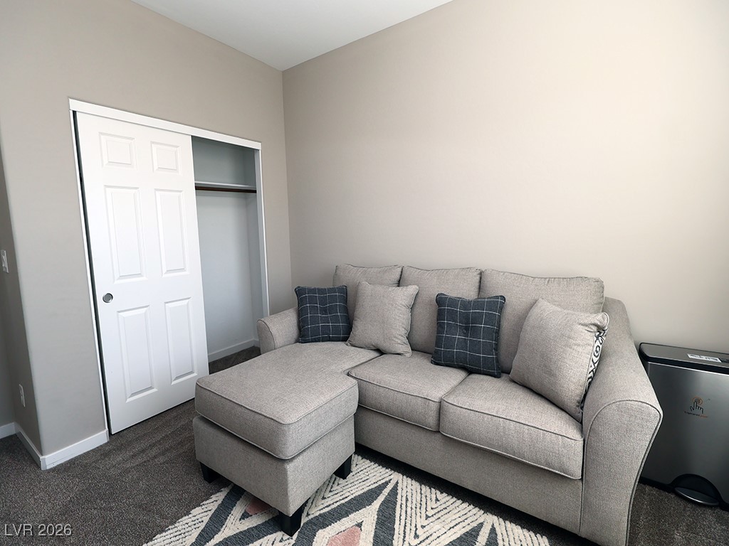 764 Rogue Wave Street Las Vegas, NV 89138 - Photo 15 of 36 Living room with dark carpet and baseboards
