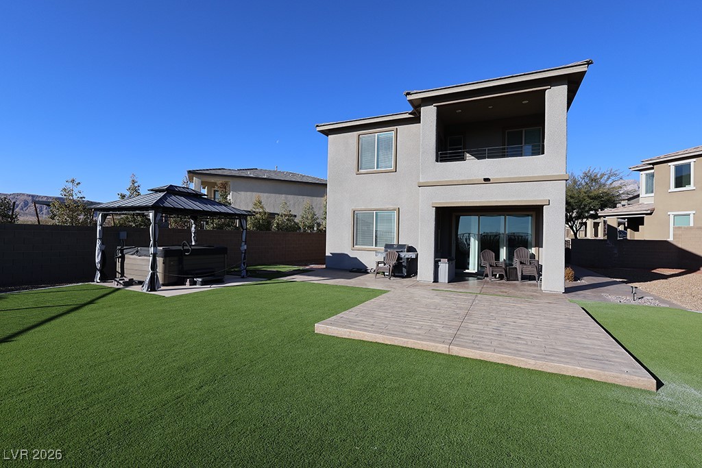 764 Rogue Wave Street Las Vegas, NV 89138 - Photo 2 of 36 Rear view of house with a hot tub, a patio, stucco siding, and a fenced backyard