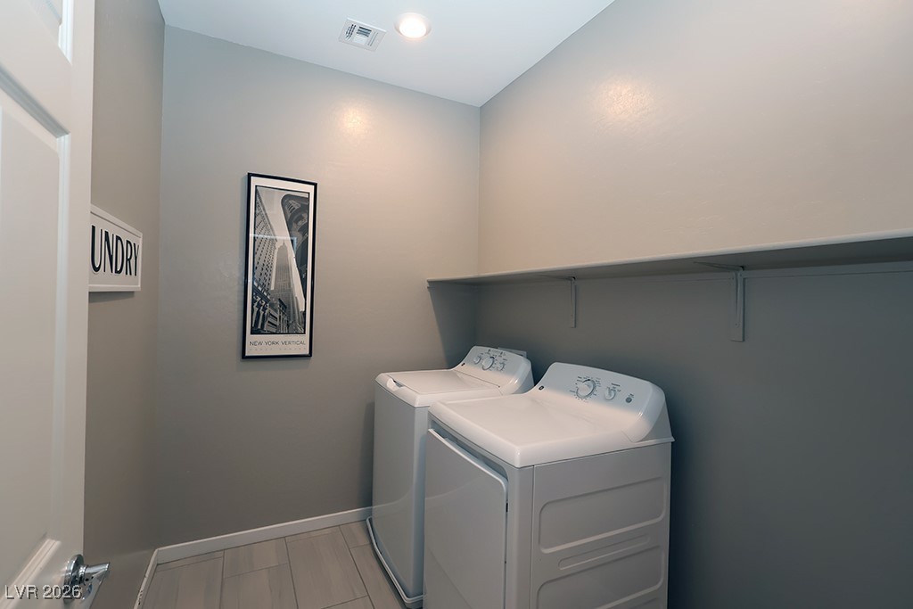 764 Rogue Wave Street Las Vegas, NV 89138 - Photo 21 of 36 Laundry room featuring washing machine and clothes dryer and wood tiled floors