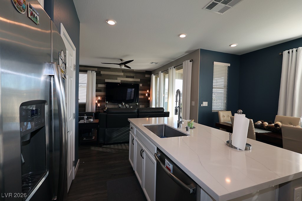 764 Rogue Wave Street Las Vegas, NV 89138 - Photo 36 of 36 Kitchen featuring stainless steel fridge with ice dispenser, open floor plan, an island with sink, dishwasher, and an accent wall