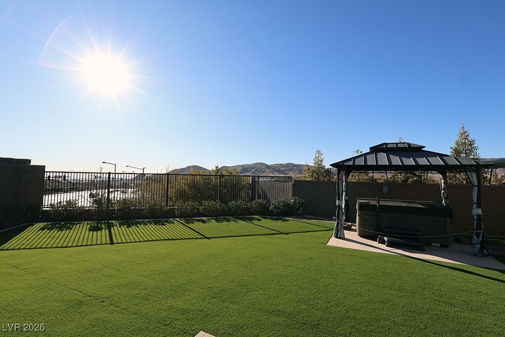 764 Rogue Wave Street Las Vegas, NV 89138 - Photo 30 of 36 Fenced backyard with a hot tub, a mountain view, a gazebo, and a patio