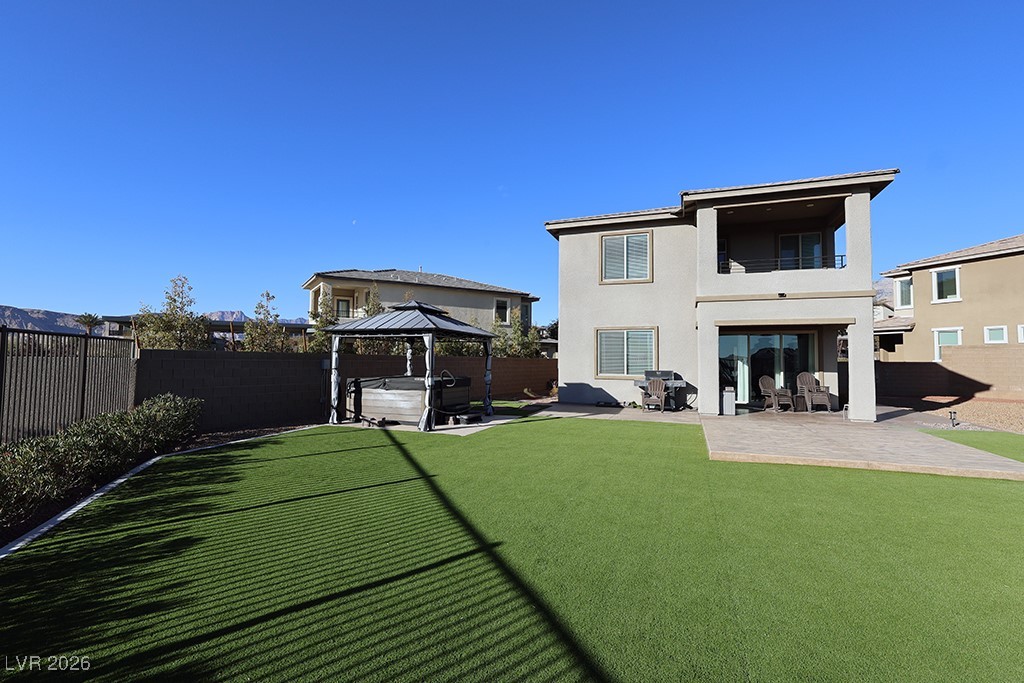 764 Rogue Wave Street Las Vegas, NV 89138 - Photo 33 of 36 Rear view of house with a hot tub, a fenced backyard, and a patio