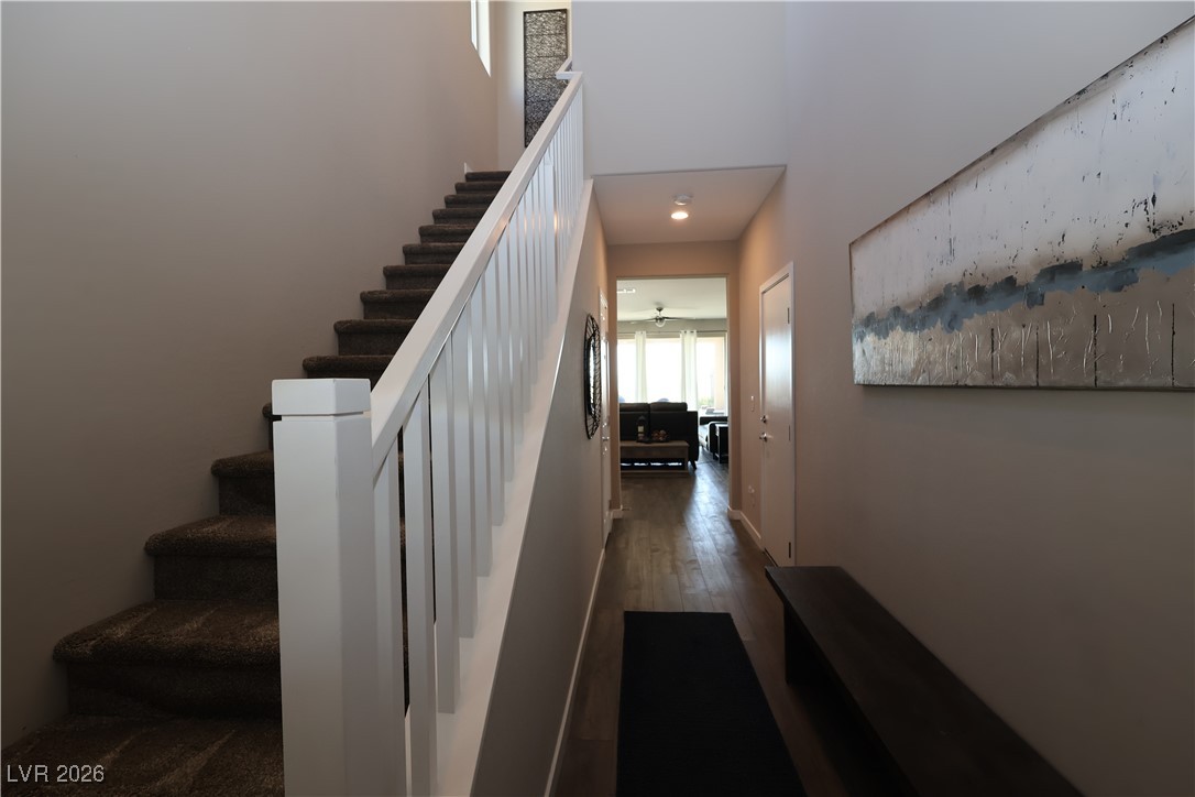 764 Rogue Wave Street Las Vegas, NV 89138 - Photo 8 of 36 Stairway with wood finished floors, a high ceiling, and ceiling fan
