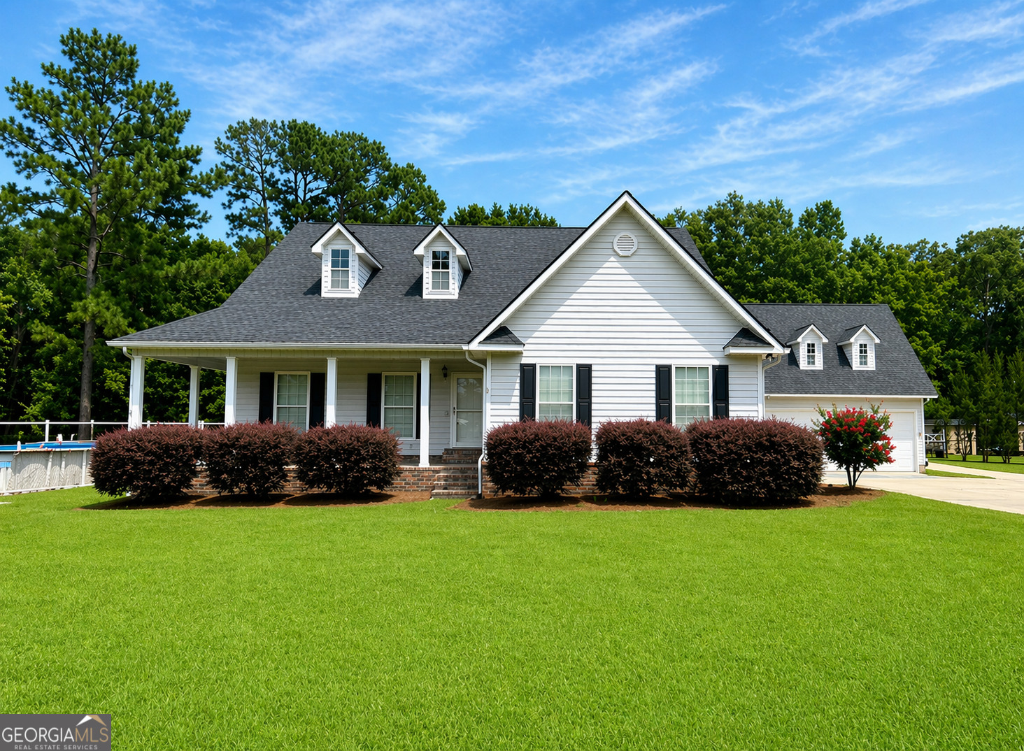 a front view of a house with a garden and yard