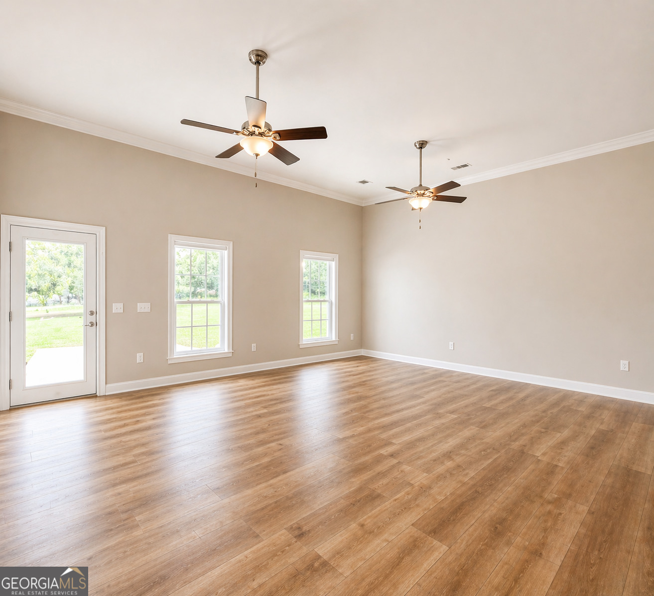 1024 Holly Estates Road Tarrytown, GA 30470 - Photo 3 of 15 an empty room with wooden floor chandelier fan and windows