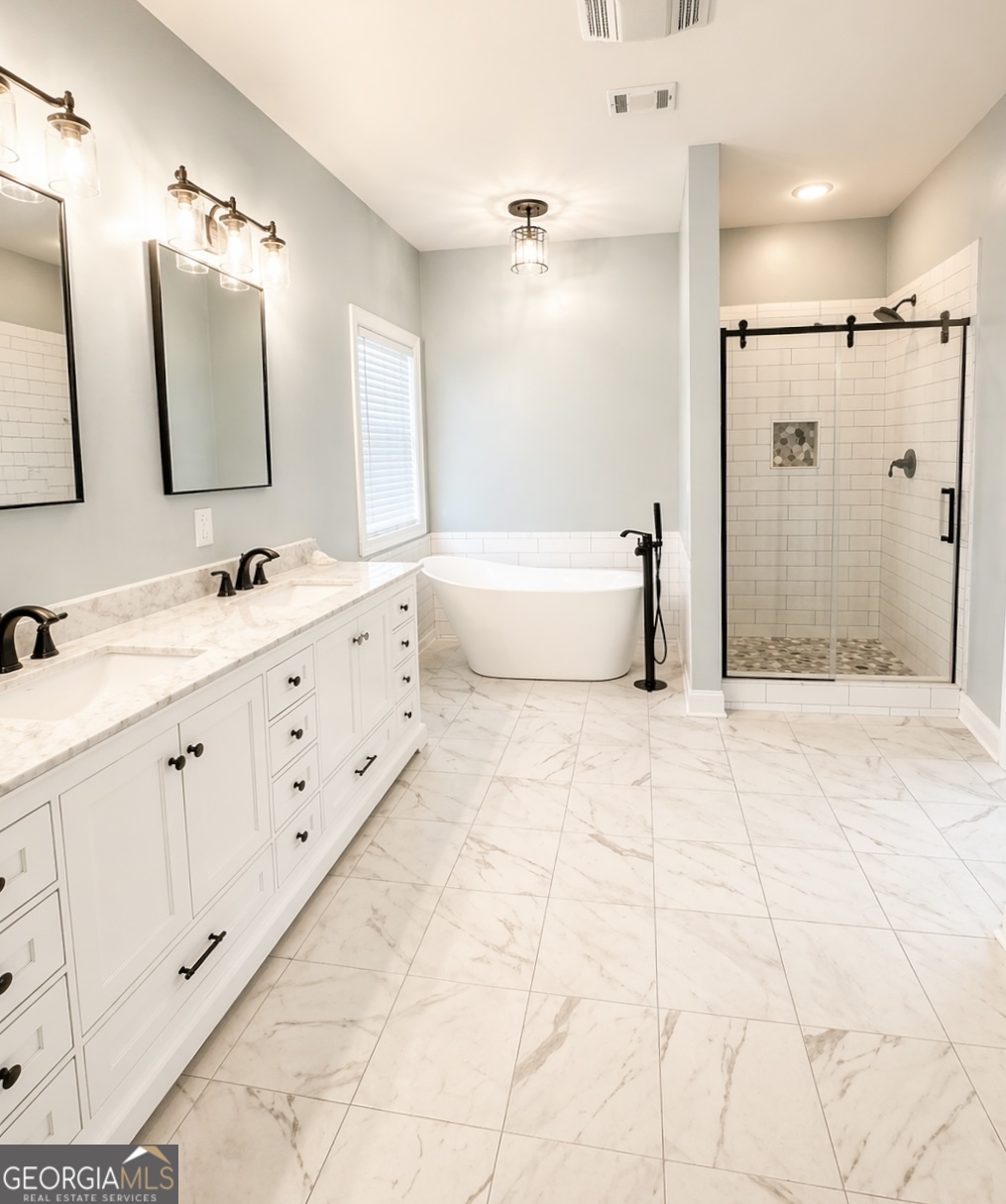 1024 Holly Estates Road Tarrytown, GA 30470 - Photo 7 of 15 a bathroom with a double vanity sink large mirror and a bathtub
