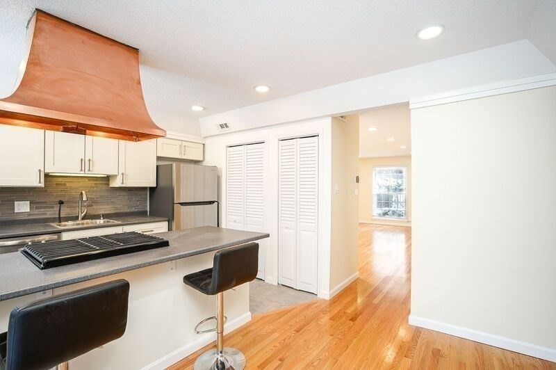58 Williamsburg Drive, Unit 58 Springfield, MA 01108 - Photo 9 of 15 a kitchen with stainless steel appliances a stove a refrigerator a sink and white cabinets with wooden floor