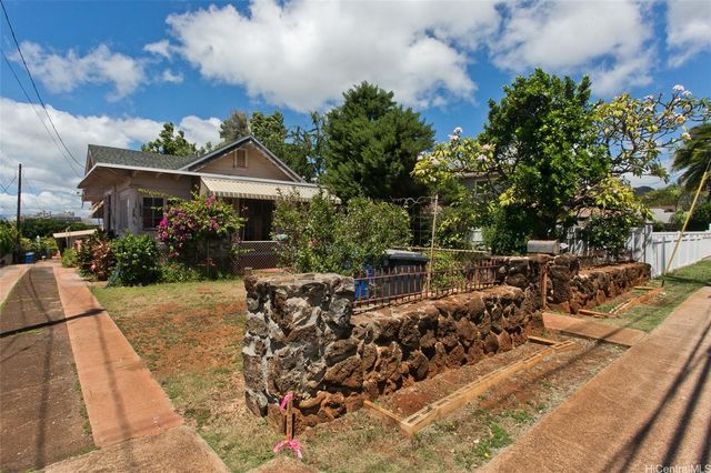 a view of a house with backyard sitting area and garden
