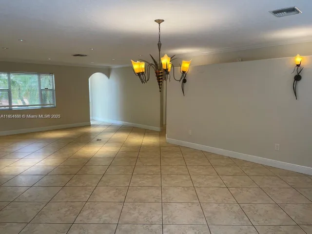 a view of a room with a chandelier fan and windows