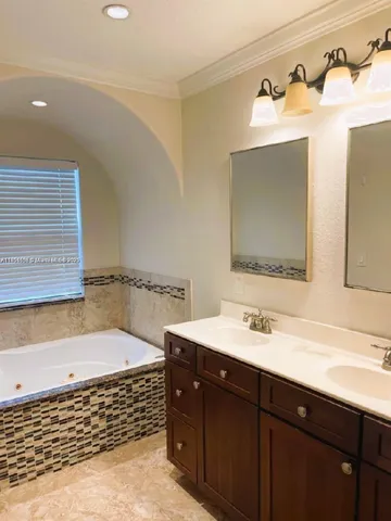 a bathroom with a tub sink and mirror