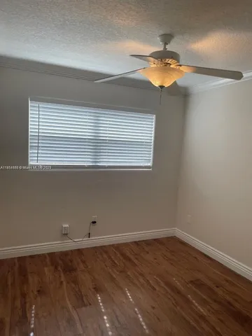 a view of a room with wooden floor and fan