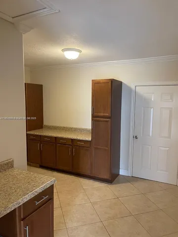 a kitchen with cabinets and refrigerator