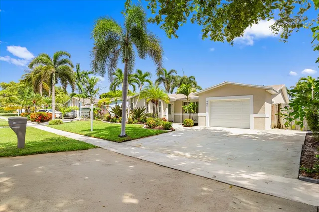 a view of a house with a yard and potted plants