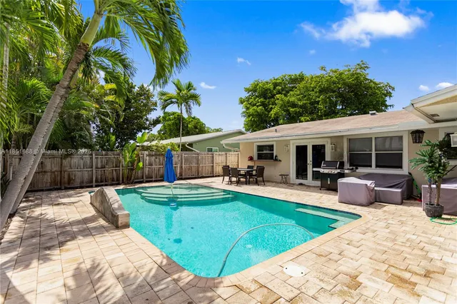 a view of a house with swimming pool and sitting area