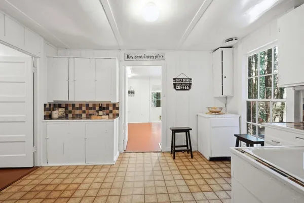 a room with a white cabinets and white appliances