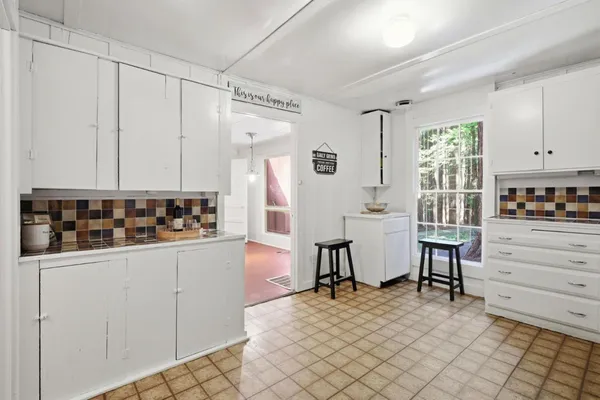 a view of kitchen with refrigerator and window