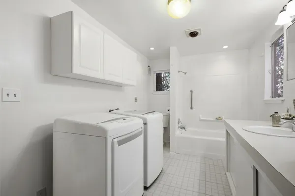 a view of a sink and dishwasher with white cabinets