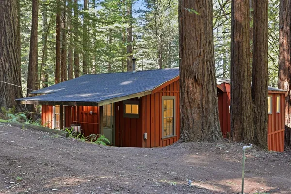 a view of a house with a yard and large tree