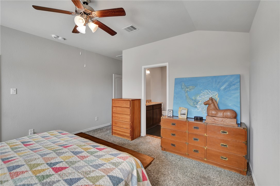909 Davy Street Brenham, TX 77833 - Photo 18 of 35 Bedroom featuring carpet, lofted ceiling, a ceiling fan, and connected bathroom